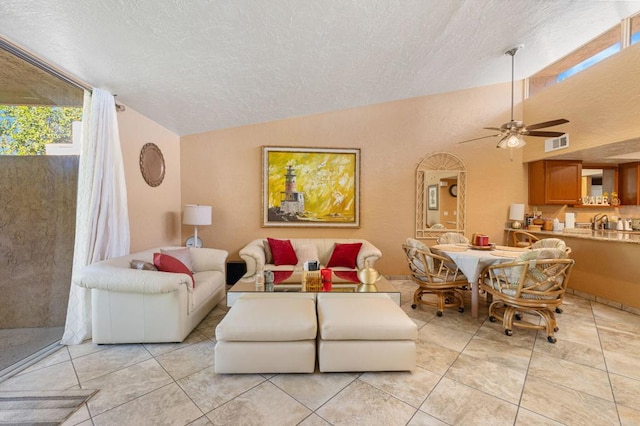 living room featuring lofted ceiling, ceiling fan, and light tile patterned flooring