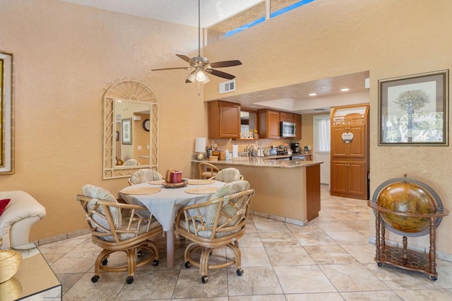 dining area with ceiling fan and light tile patterned flooring