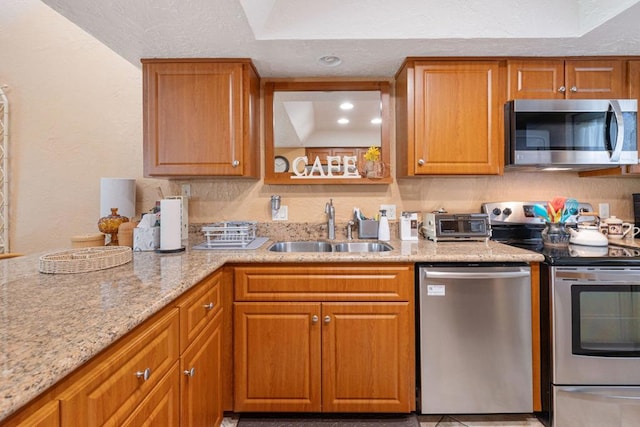 kitchen featuring light stone countertops, sink, and appliances with stainless steel finishes