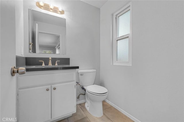 bathroom with tile patterned flooring, vanity, and toilet