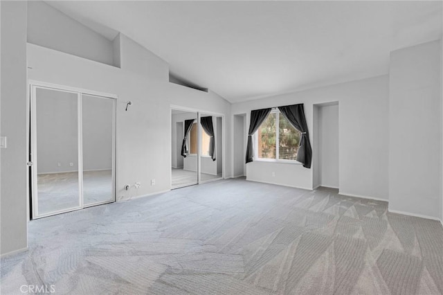 interior space with light colored carpet and vaulted ceiling