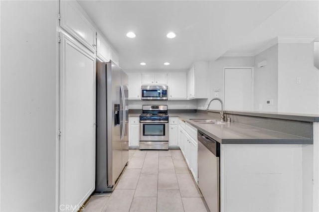 kitchen with sink, ornamental molding, white cabinetry, kitchen peninsula, and stainless steel appliances