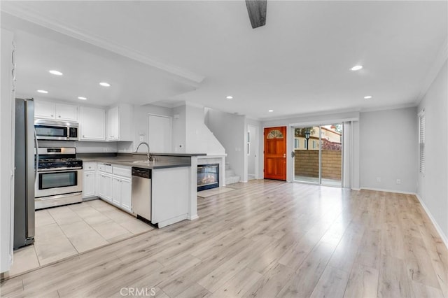 kitchen with white cabinetry, sink, kitchen peninsula, light hardwood / wood-style floors, and appliances with stainless steel finishes