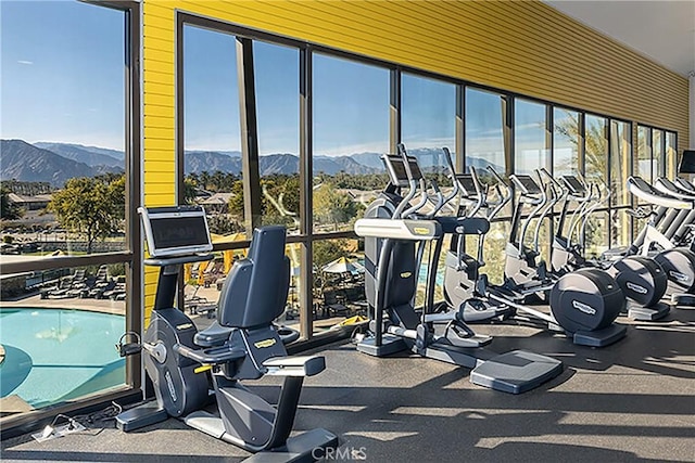 exercise room featuring a mountain view and a wall of windows