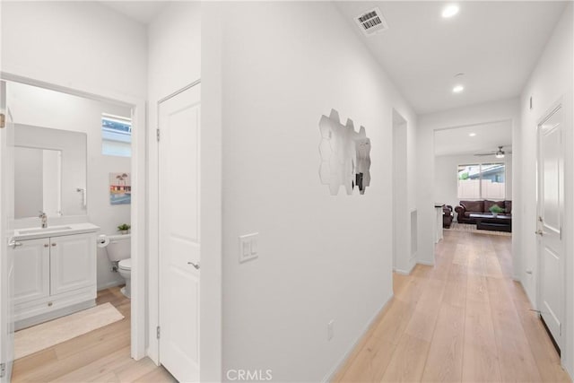 hall featuring sink and light hardwood / wood-style flooring