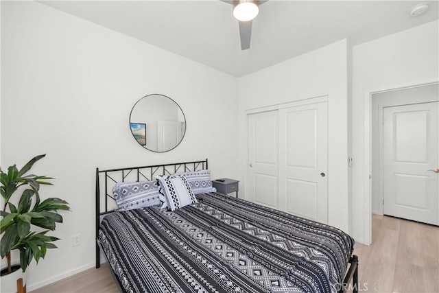 bedroom with ceiling fan, a closet, and light hardwood / wood-style flooring