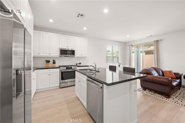 kitchen with sink, light hardwood / wood-style flooring, a center island with sink, stainless steel appliances, and white cabinets