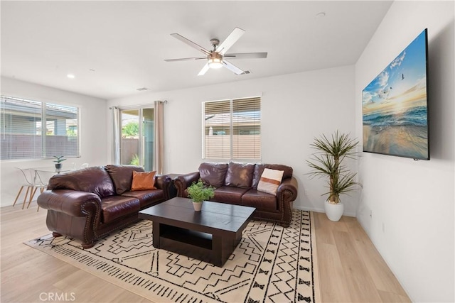 living room with ceiling fan and light hardwood / wood-style flooring