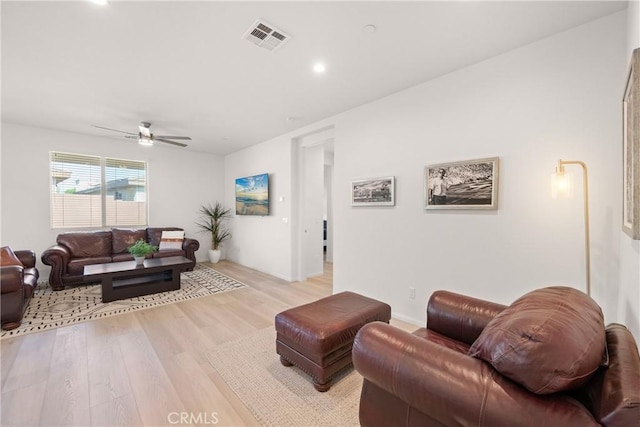 living room with ceiling fan and light hardwood / wood-style flooring