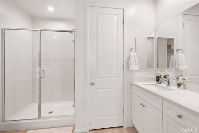 bathroom featuring vanity, hardwood / wood-style floors, and a shower with shower door