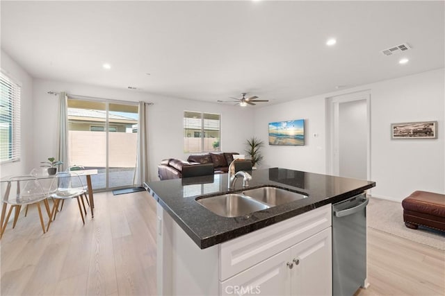 kitchen with sink, dishwasher, an island with sink, white cabinets, and light wood-type flooring