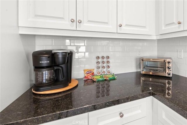 kitchen featuring tasteful backsplash and white cabinetry