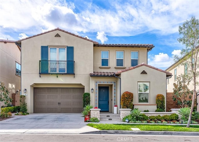 mediterranean / spanish-style house with driveway, a tiled roof, an attached garage, and stucco siding