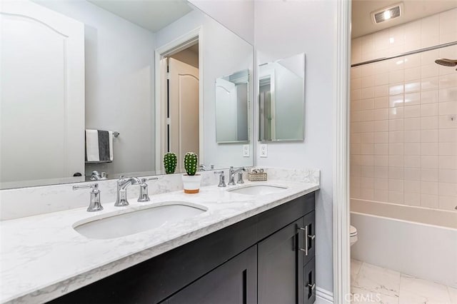 full bath featuring double vanity, visible vents, toilet, and a sink