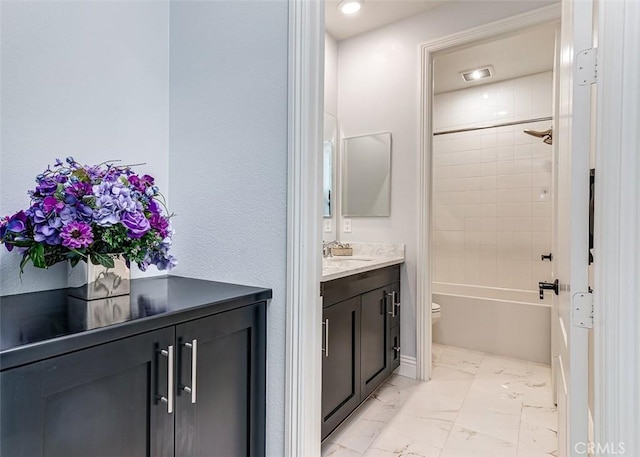 bathroom with marble finish floor, shower / bath combination, vanity, and toilet