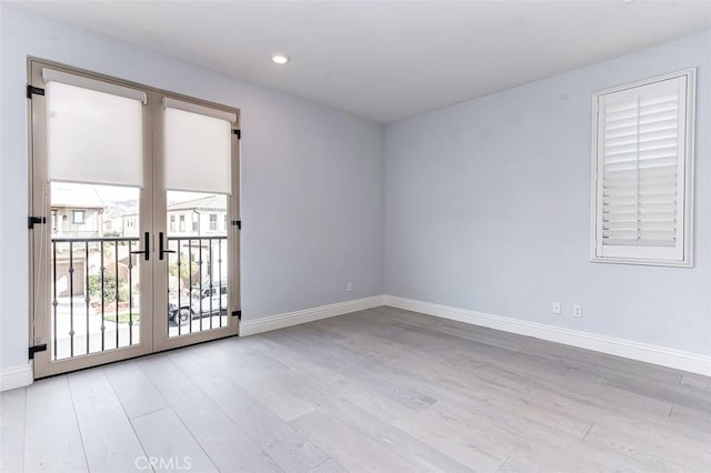 unfurnished room with recessed lighting, baseboards, wood finished floors, and french doors