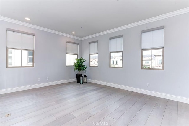 unfurnished room featuring ornamental molding, light wood-style flooring, and baseboards