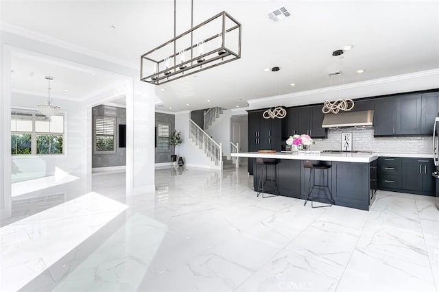 kitchen with ornamental molding, marble finish floor, light countertops, and under cabinet range hood