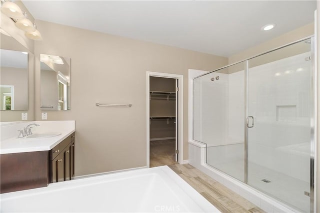 bathroom featuring hardwood / wood-style flooring, vanity, and a shower with shower door