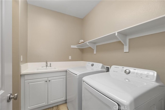laundry area with washer and dryer, sink, and cabinets