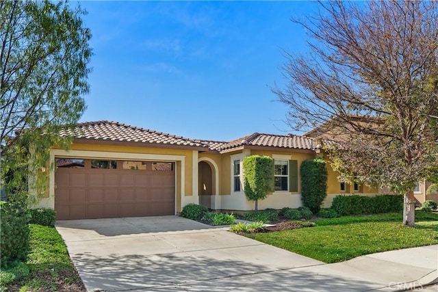 mediterranean / spanish-style house featuring a front lawn and a garage