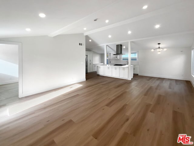 unfurnished living room featuring vaulted ceiling with beams, dark hardwood / wood-style flooring, and an inviting chandelier