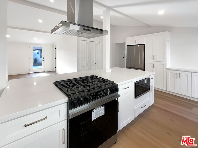 kitchen featuring island exhaust hood, vaulted ceiling, black appliances, light hardwood / wood-style flooring, and white cabinetry