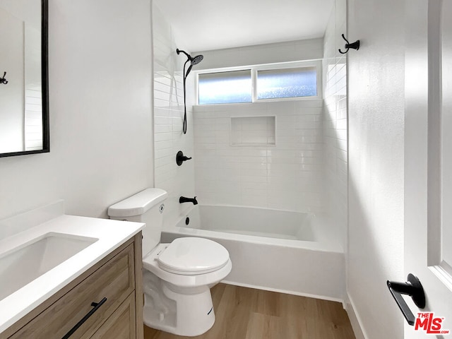 full bathroom featuring hardwood / wood-style floors, vanity, toilet, and tiled shower / bath combo