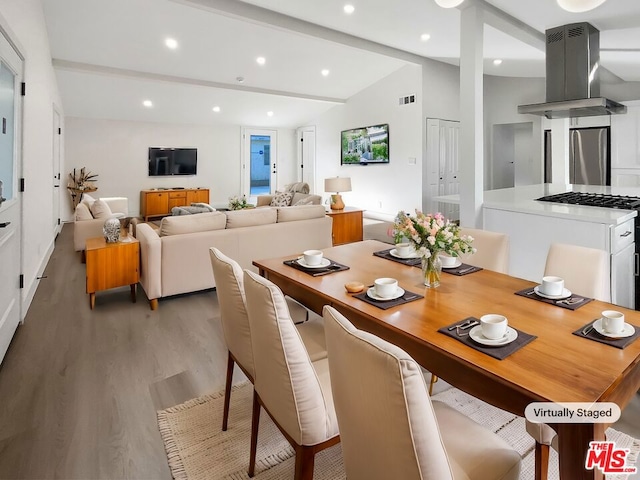 dining room with lofted ceiling with beams and hardwood / wood-style flooring