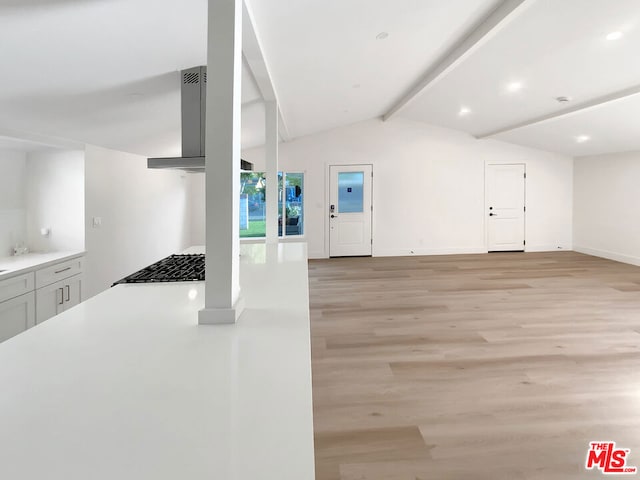 unfurnished living room featuring lofted ceiling with beams and light wood-type flooring