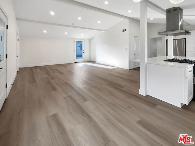 unfurnished living room with vaulted ceiling with beams and light hardwood / wood-style flooring