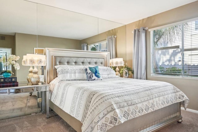 carpeted bedroom featuring multiple windows