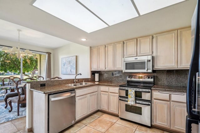 kitchen with backsplash, appliances with stainless steel finishes, sink, and light tile patterned floors