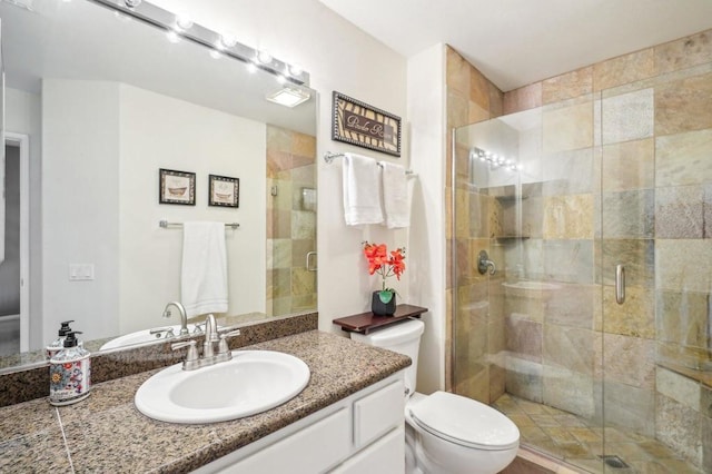 bathroom featuring vanity, toilet, and an enclosed shower