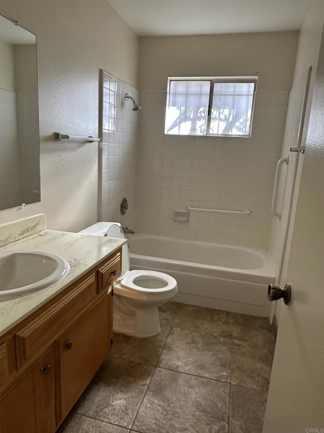 full bathroom featuring toilet, tiled shower / bath, and vanity