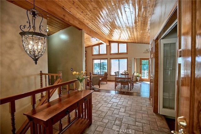 interior space featuring lofted ceiling with beams, brick floor, wood ceiling, and a notable chandelier