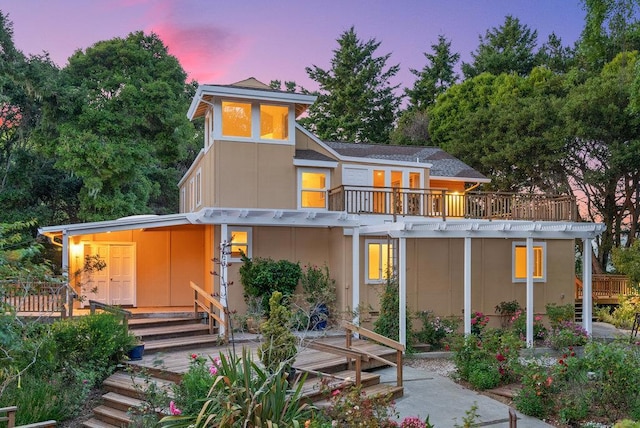 back house at dusk with a balcony