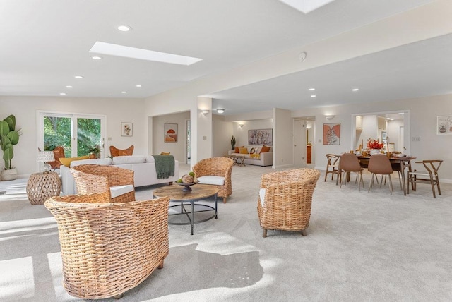 carpeted living room featuring a skylight