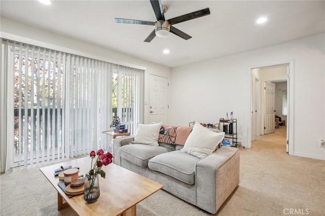 carpeted living room with ceiling fan