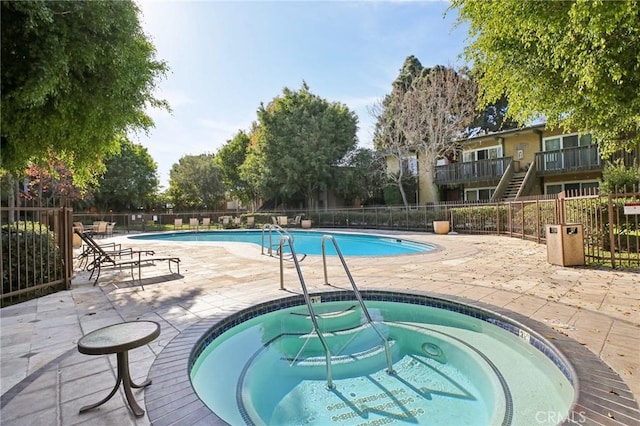 view of swimming pool featuring a patio area and a community hot tub