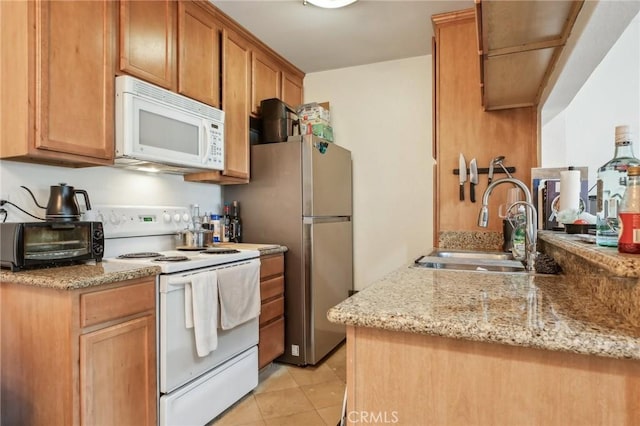 kitchen with sink, light stone counters, kitchen peninsula, white appliances, and light tile patterned floors