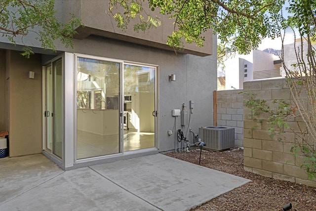 doorway to property with a patio area and central AC