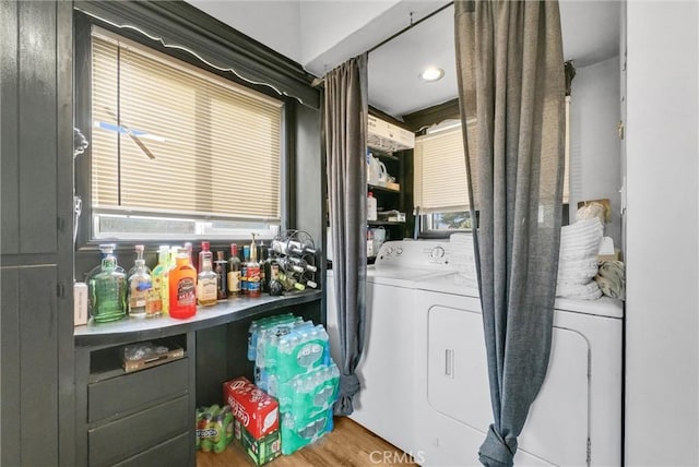 laundry room with a wealth of natural light, washer and clothes dryer, and hardwood / wood-style floors