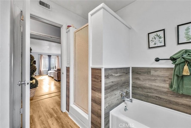 bathroom featuring shower with separate bathtub and hardwood / wood-style flooring