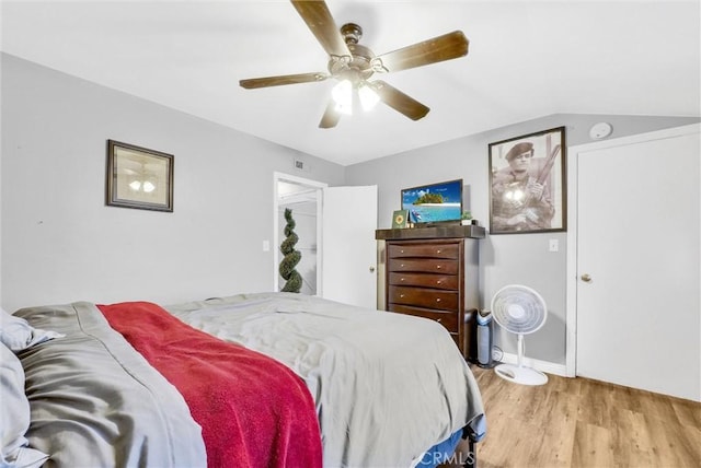 bedroom featuring ceiling fan, light hardwood / wood-style floors, and lofted ceiling