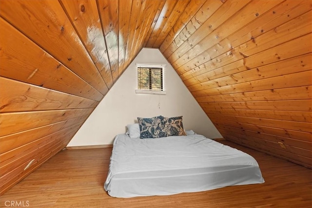 unfurnished bedroom featuring wooden walls, light hardwood / wood-style flooring, wooden ceiling, and lofted ceiling