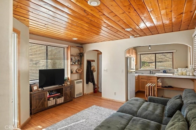 living room with light hardwood / wood-style floors, wooden ceiling, and sink