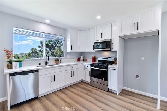 kitchen featuring light hardwood / wood-style flooring, stainless steel appliances, white cabinetry, and sink