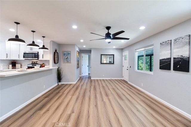 unfurnished living room with ceiling fan and light wood-type flooring