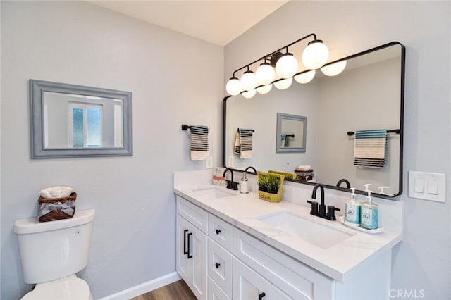 bathroom with toilet, vanity, and hardwood / wood-style flooring